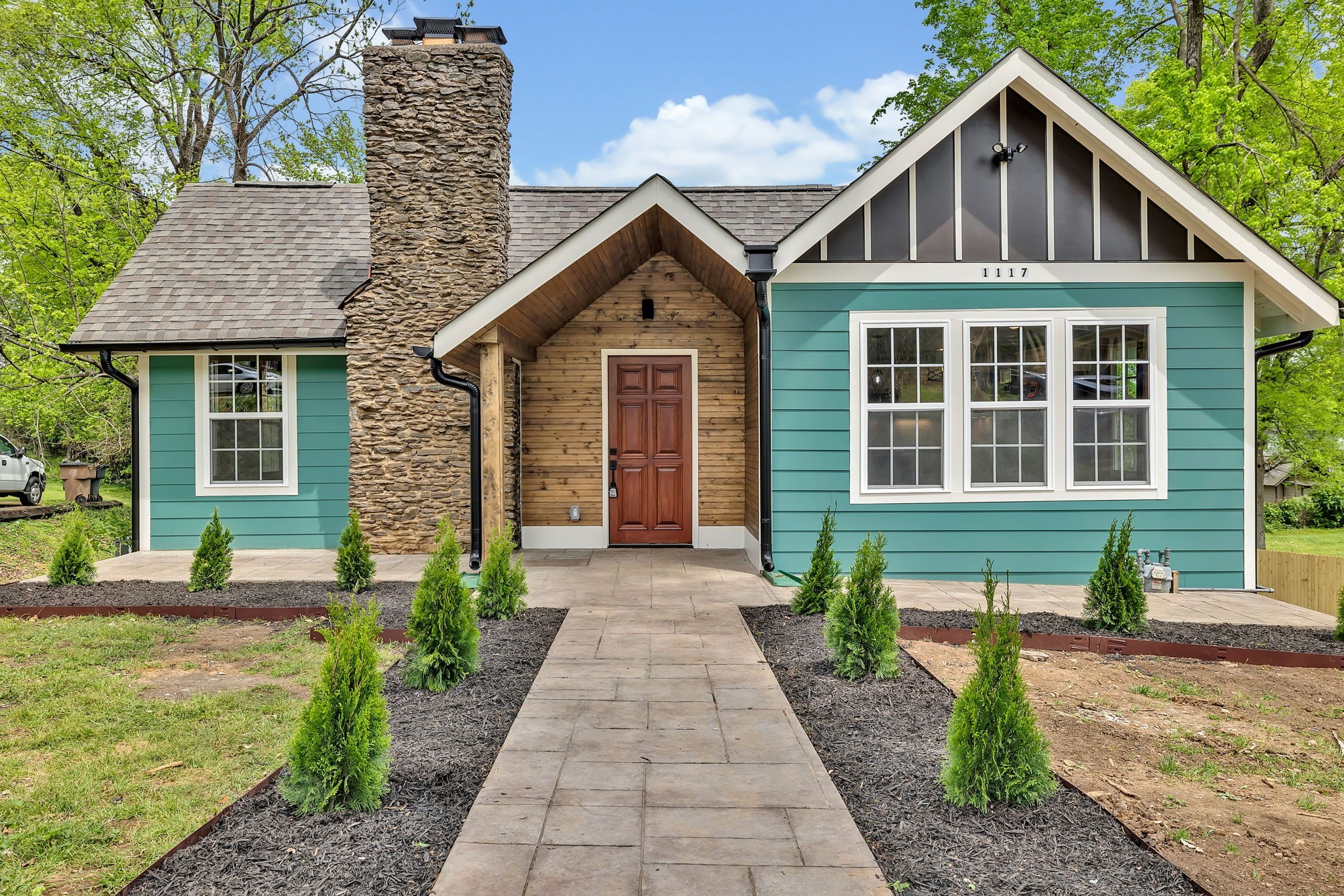 a front view of a house with a yard and potted plants