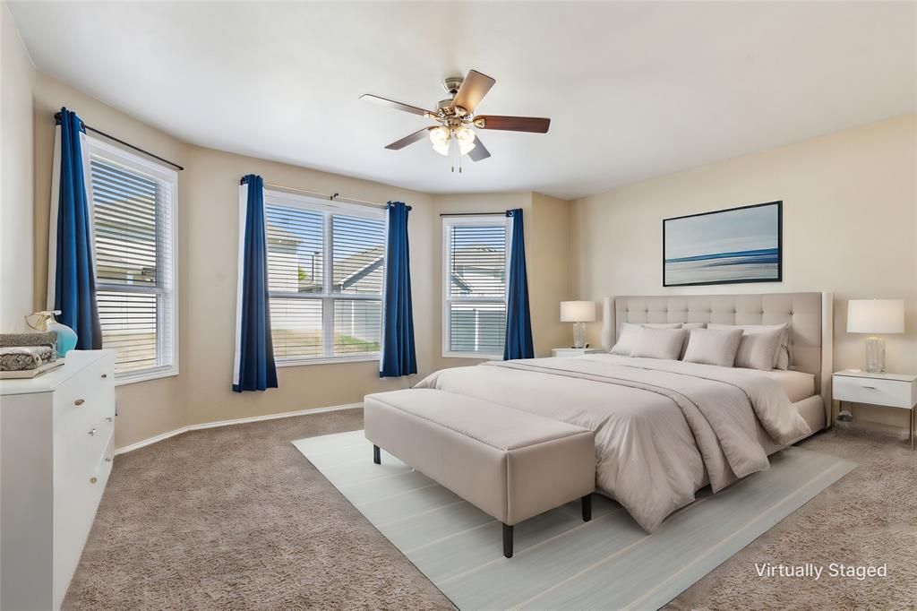 a spacious bedroom with a large bed and a chandelier fan