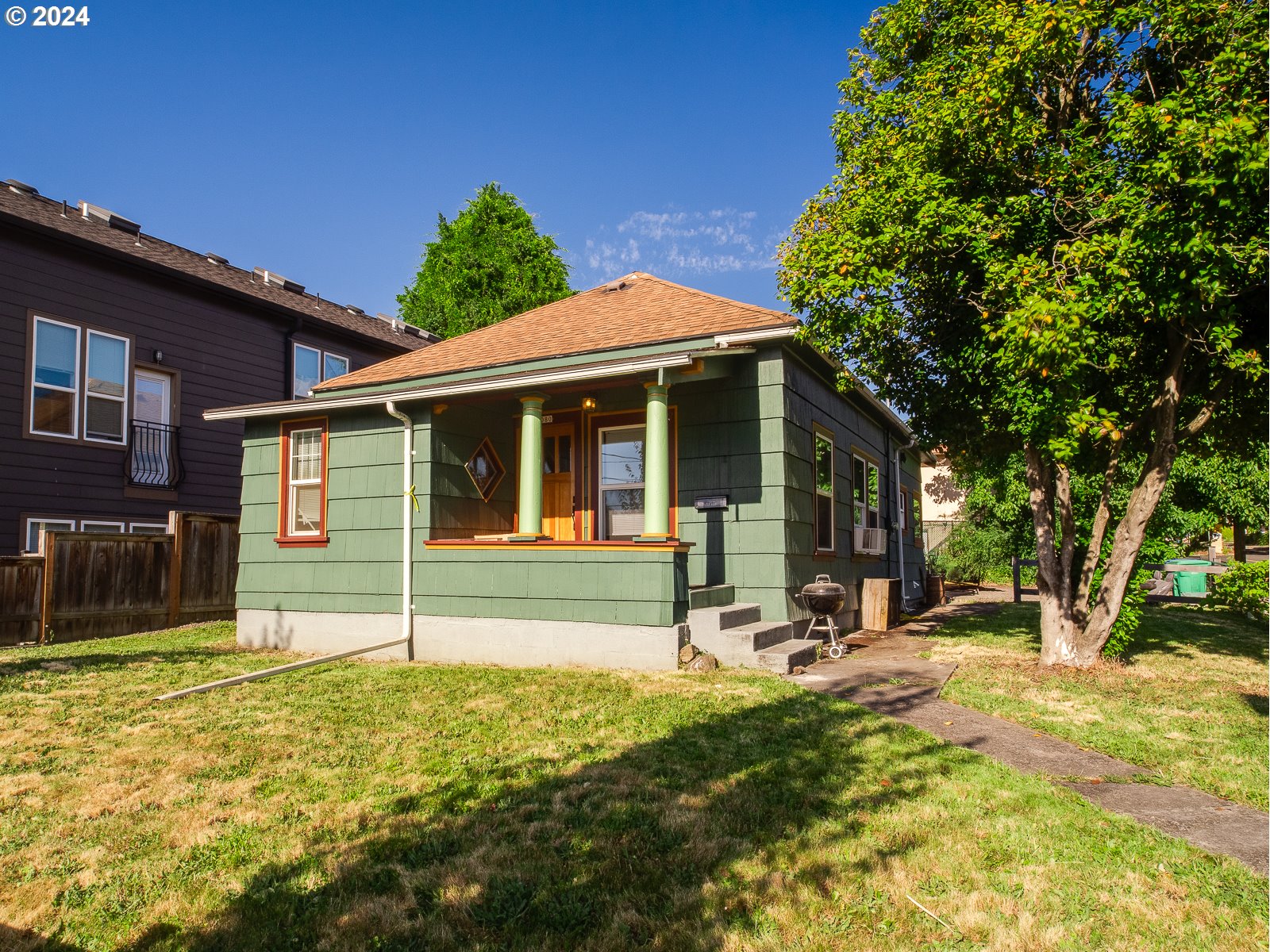 a view of a house with backyard and sitting area