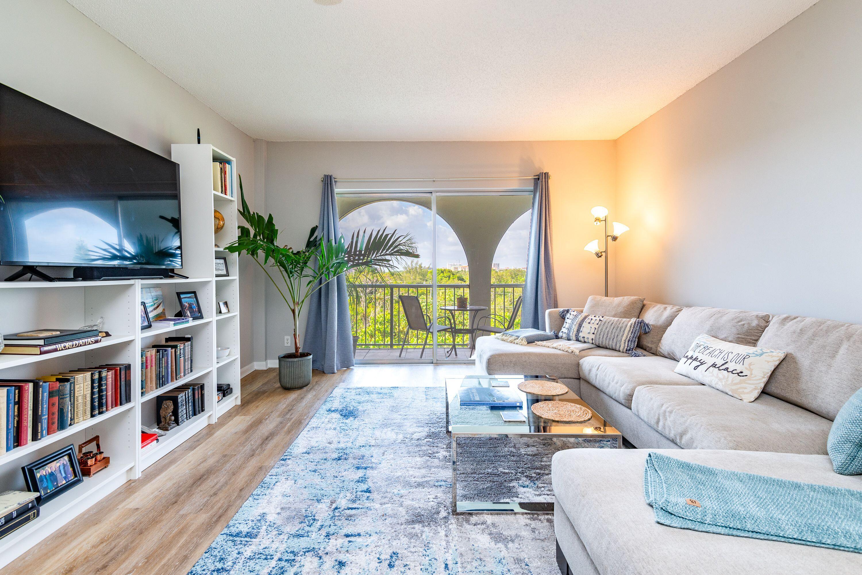 a living room with furniture a window and a flat screen tv