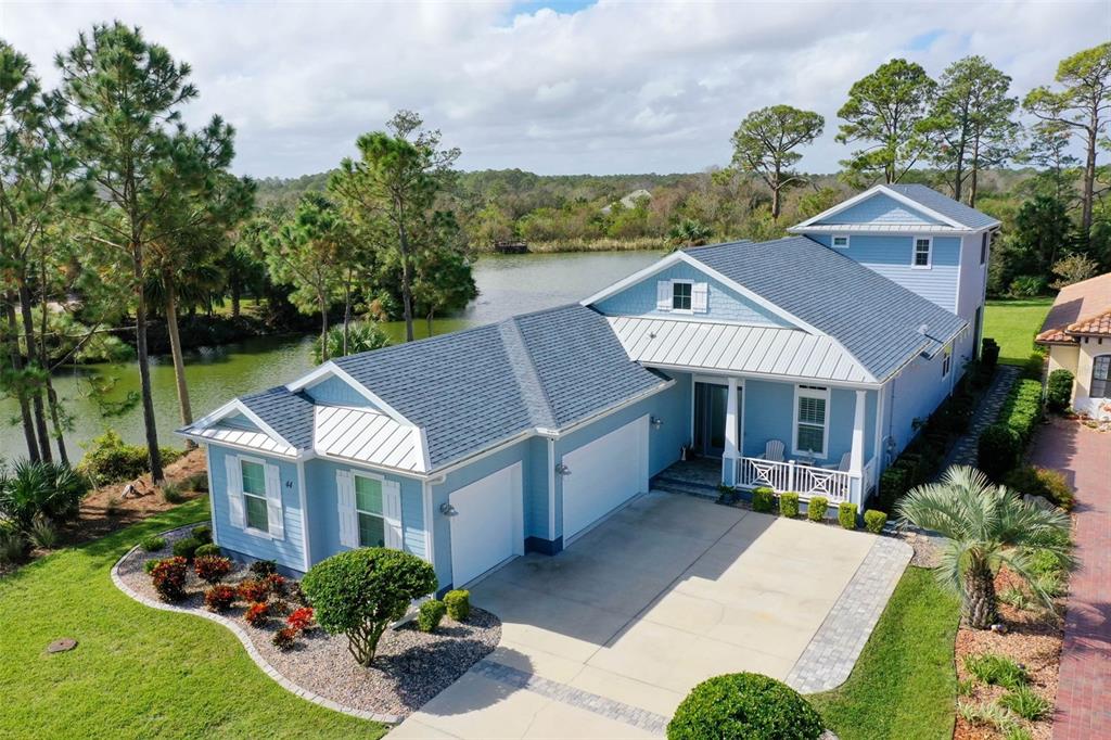 a aerial view of a house with a yard plants and large tree