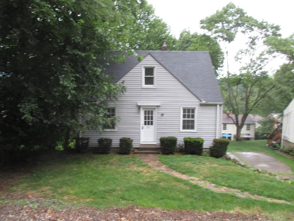 a view of a white house in a big yard with large trees