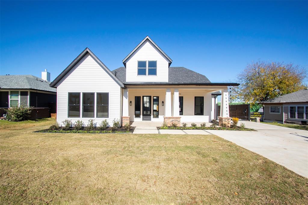 a front view of a house with a yard and porch with outdoor seating