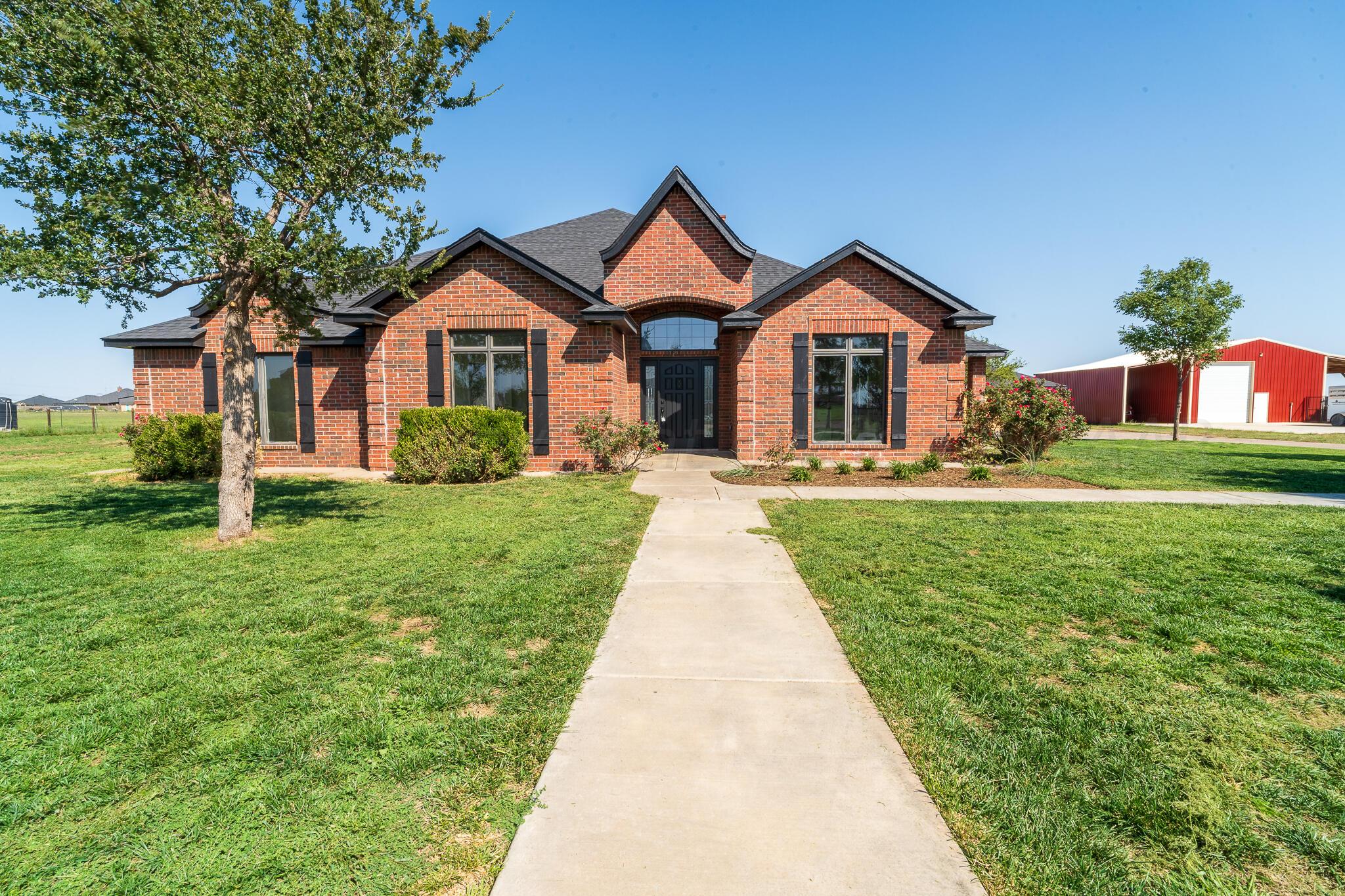 a front view of a house with yard and green space