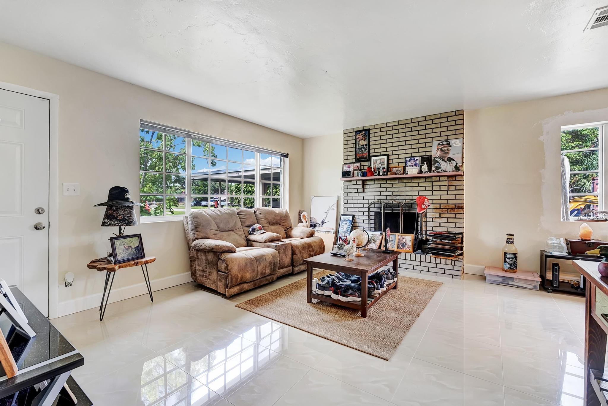 a living room with furniture large window and a fireplace