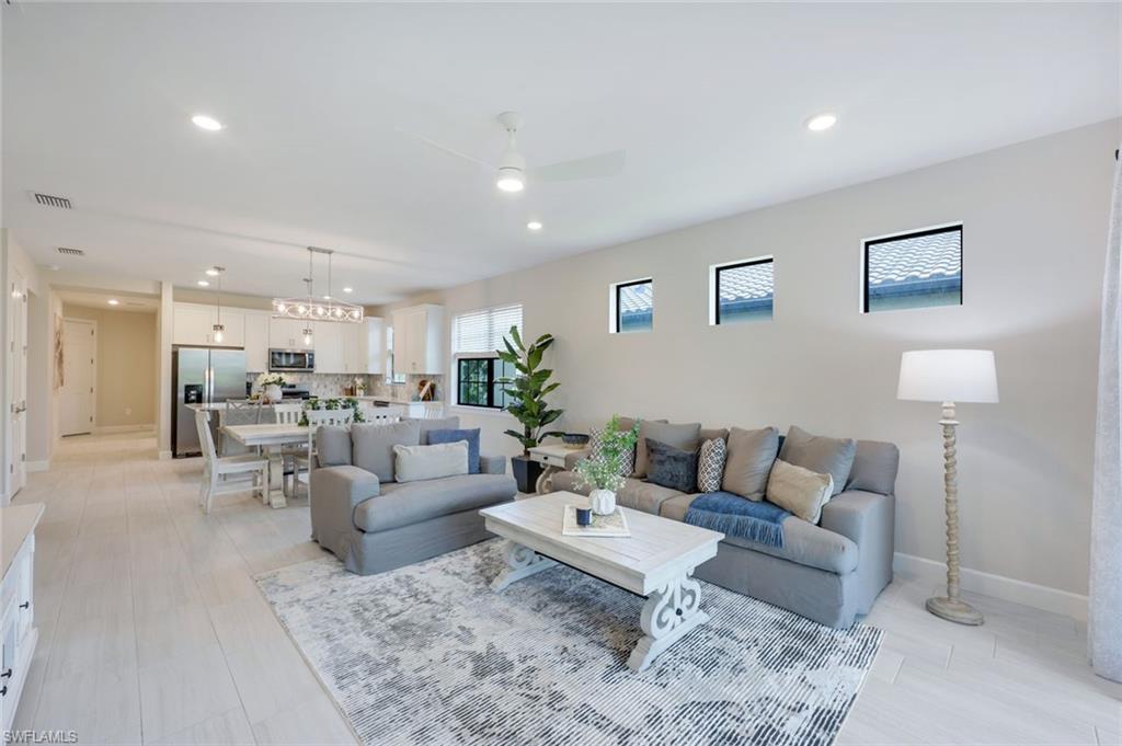 a living room with furniture and view of kitchen