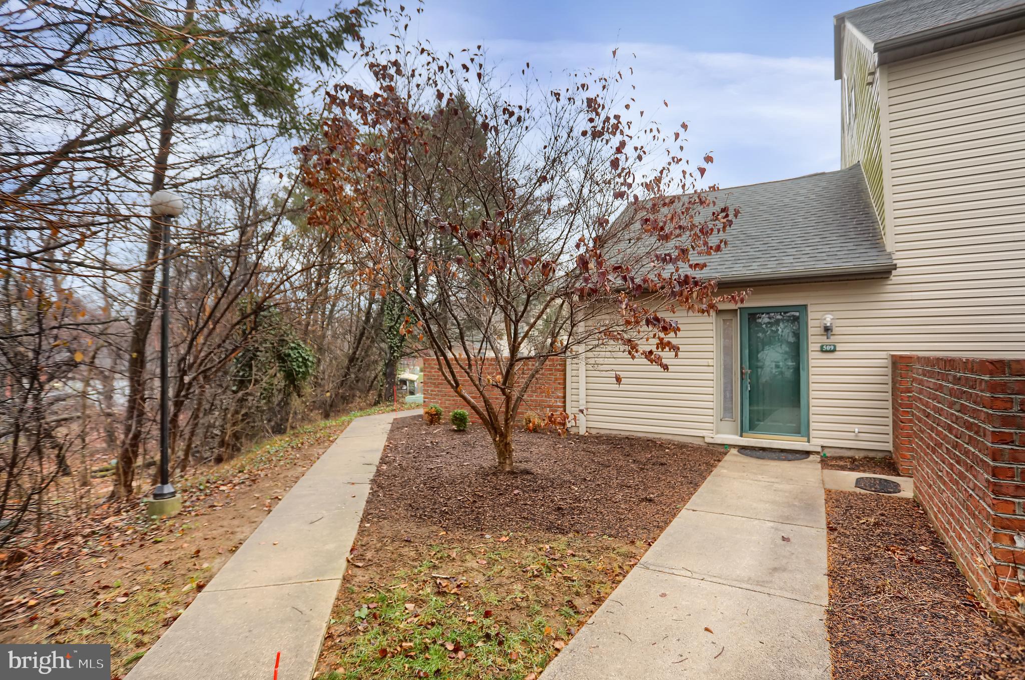 a front view of a house with a tree