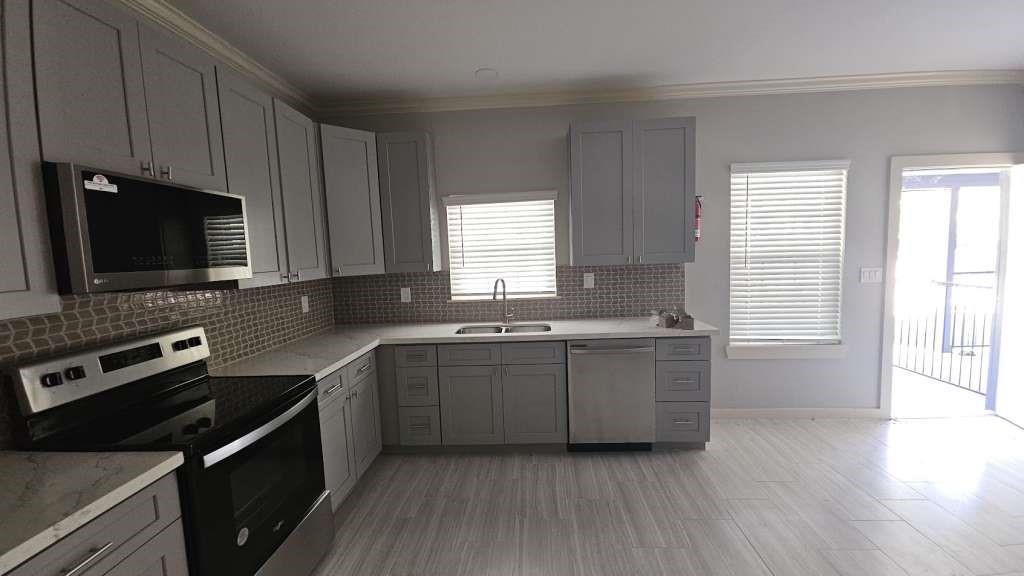 a kitchen with a sink stove and microwave