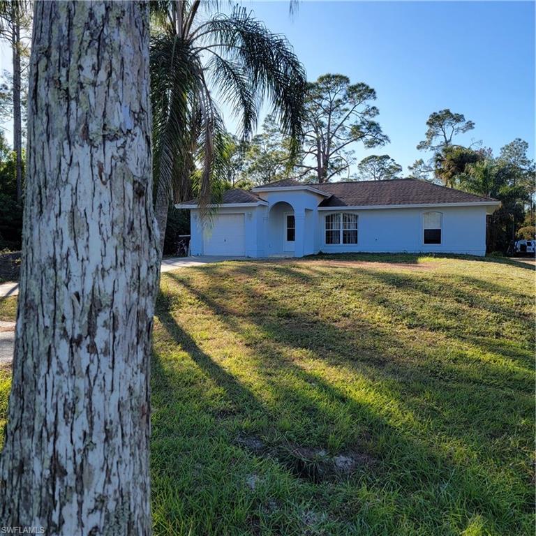 Ranch-style house featuring a garage and a front lawn