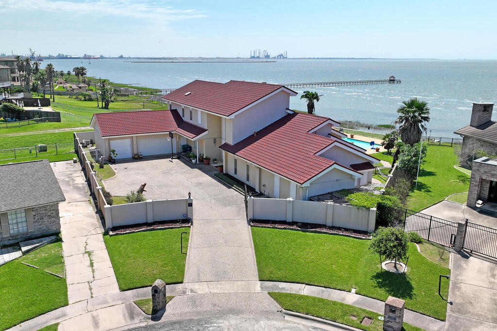 an aerial view of a house with a garden and lake view