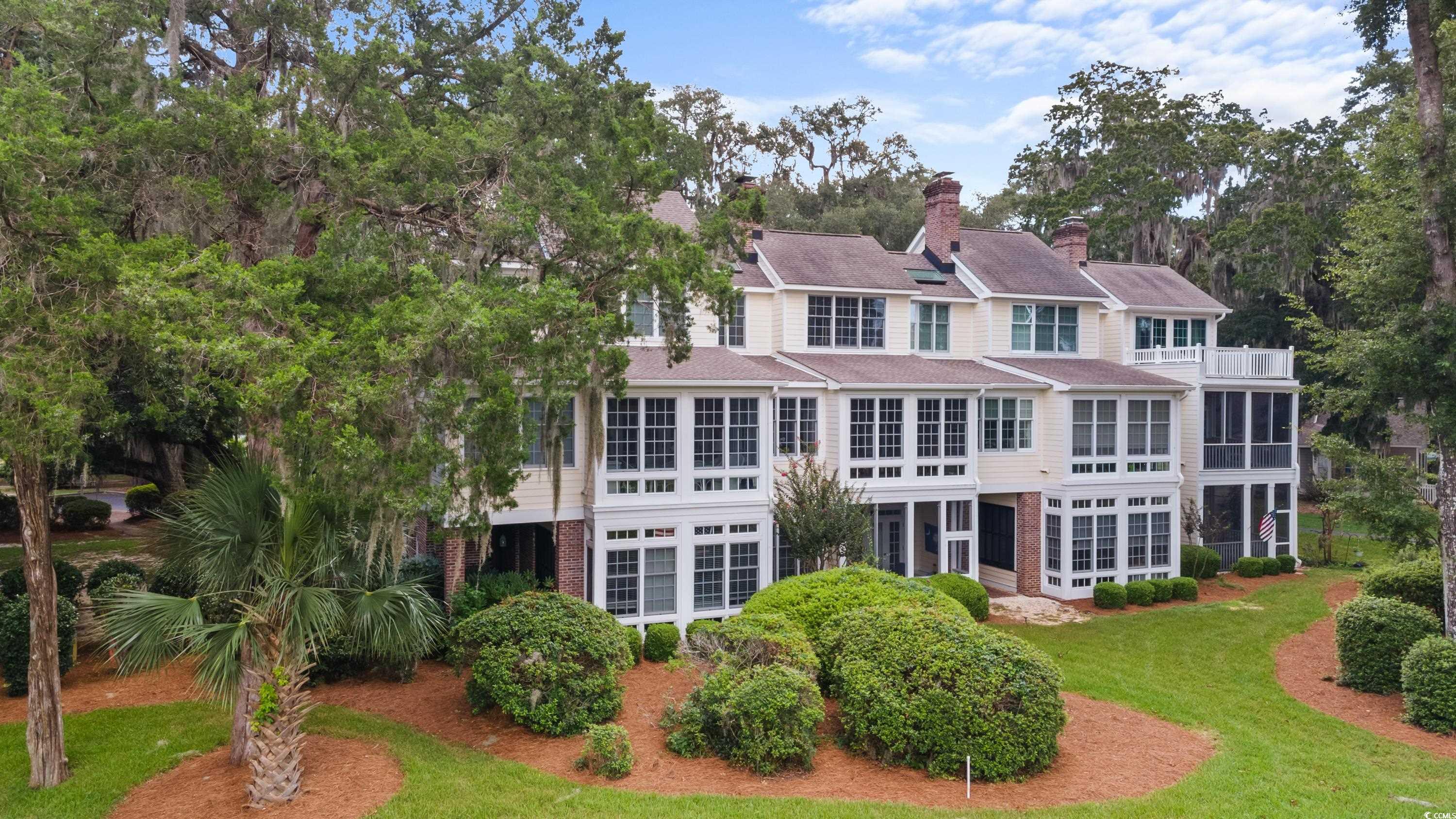 Rear view of house featuring a balcony and a lawn