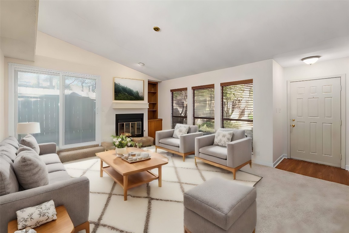 a living room with furniture fireplace and a large window