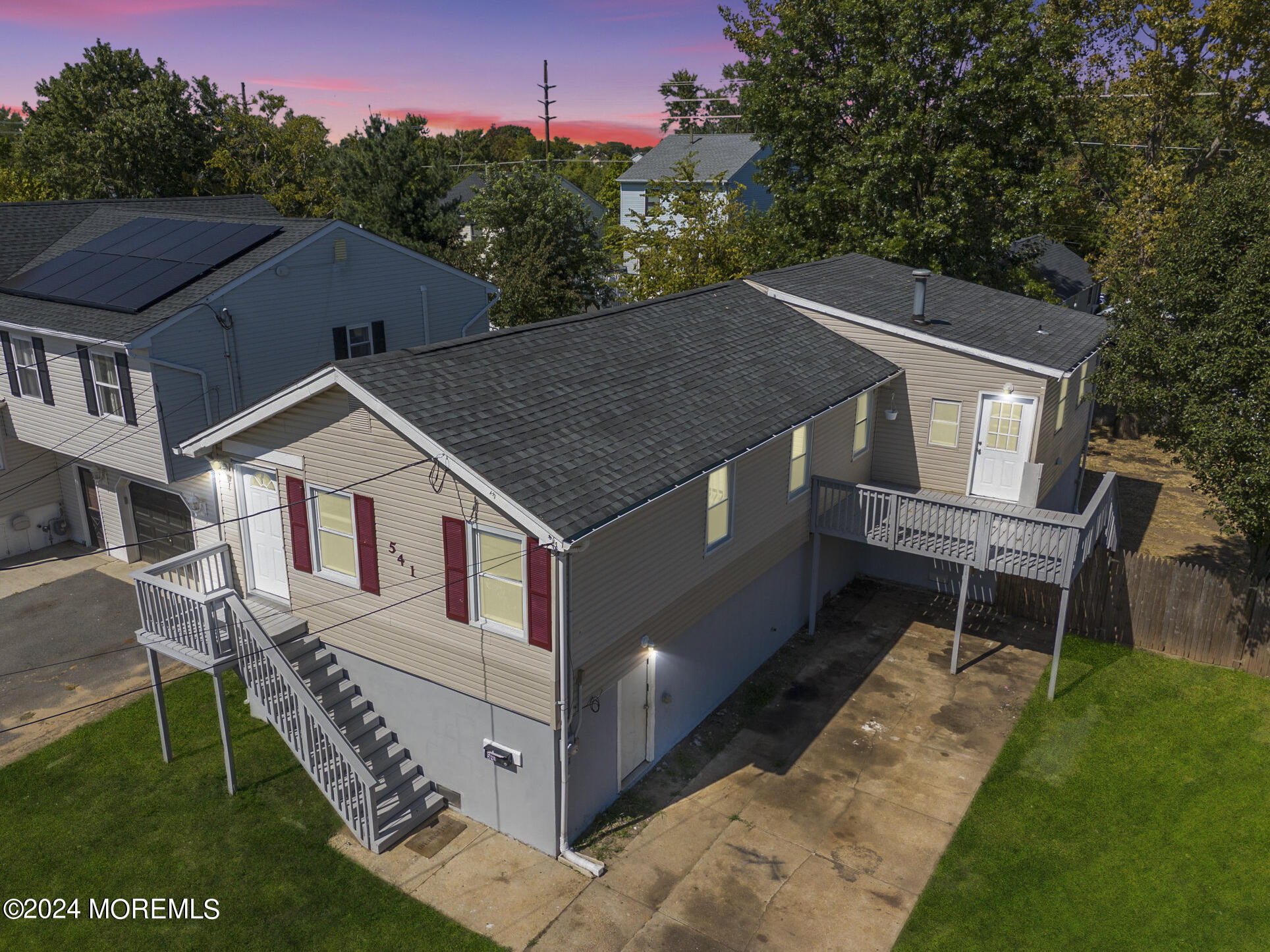 a aerial view of a house with a yard deck and furniture