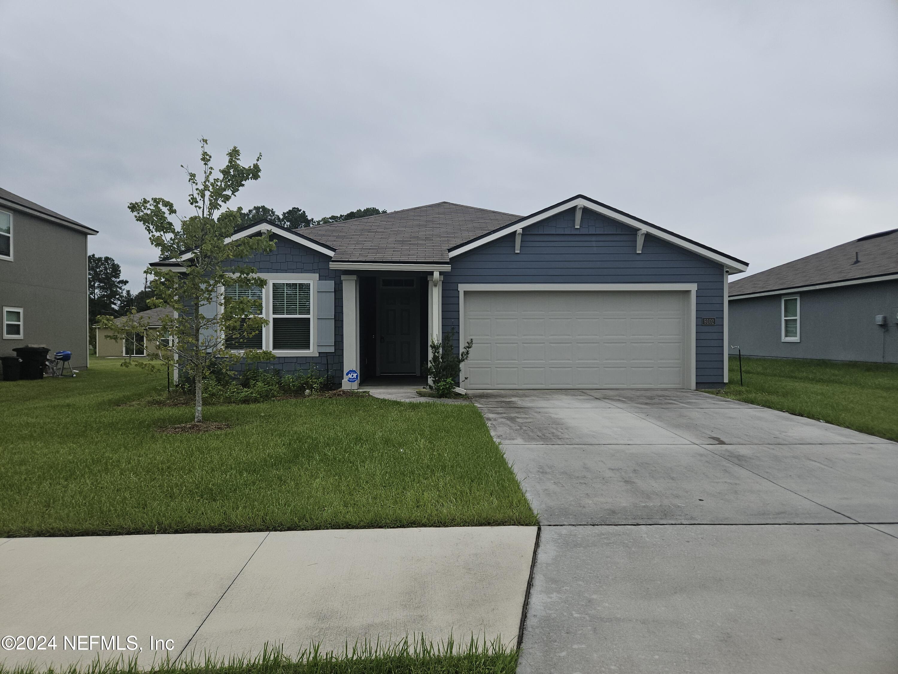 a front view of a house with a garden and yard