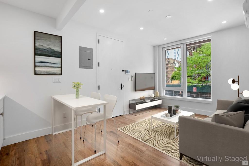 a living room with furniture a large window and a wooden floor