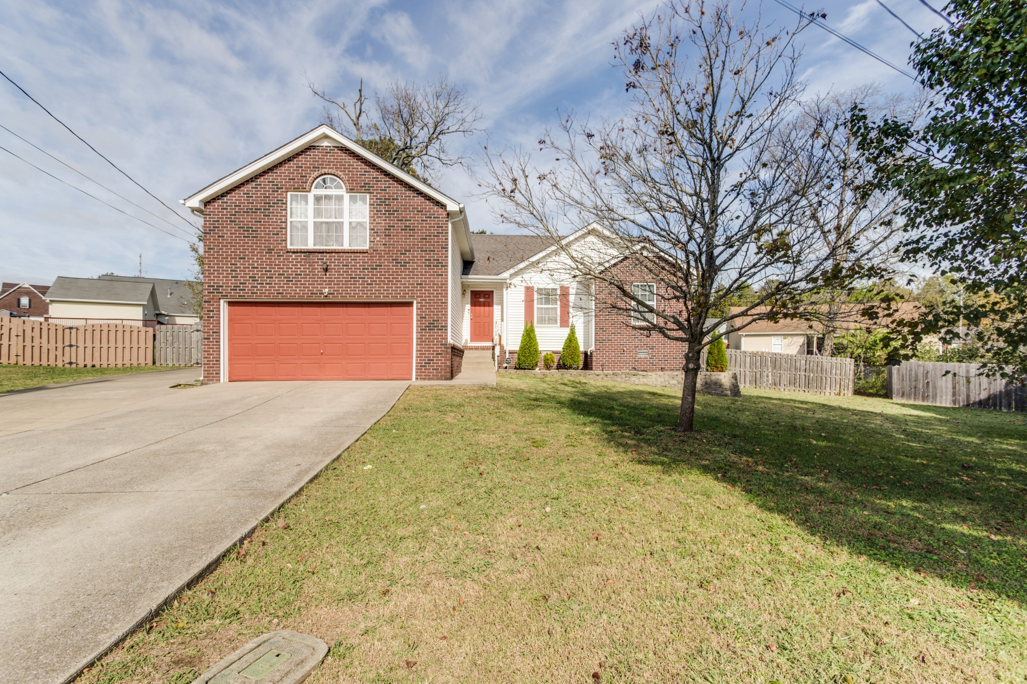 a front view of a house with a yard and trees