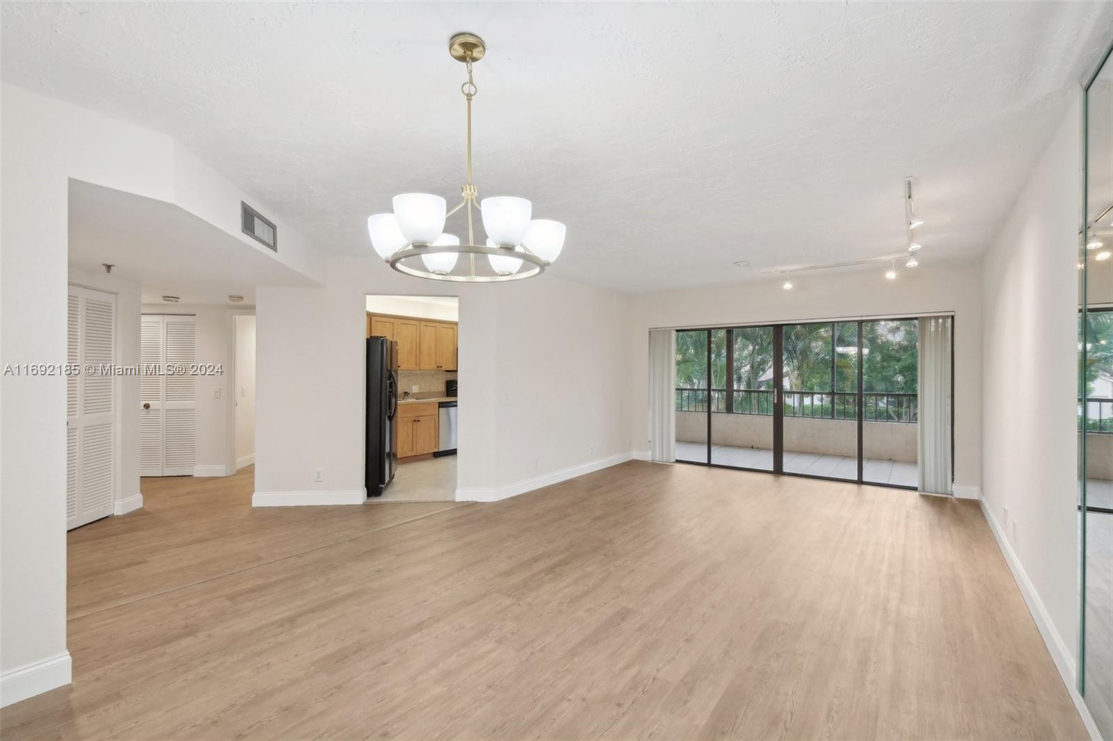 a view of a livingroom with a chandelier wooden floor and a chandelier