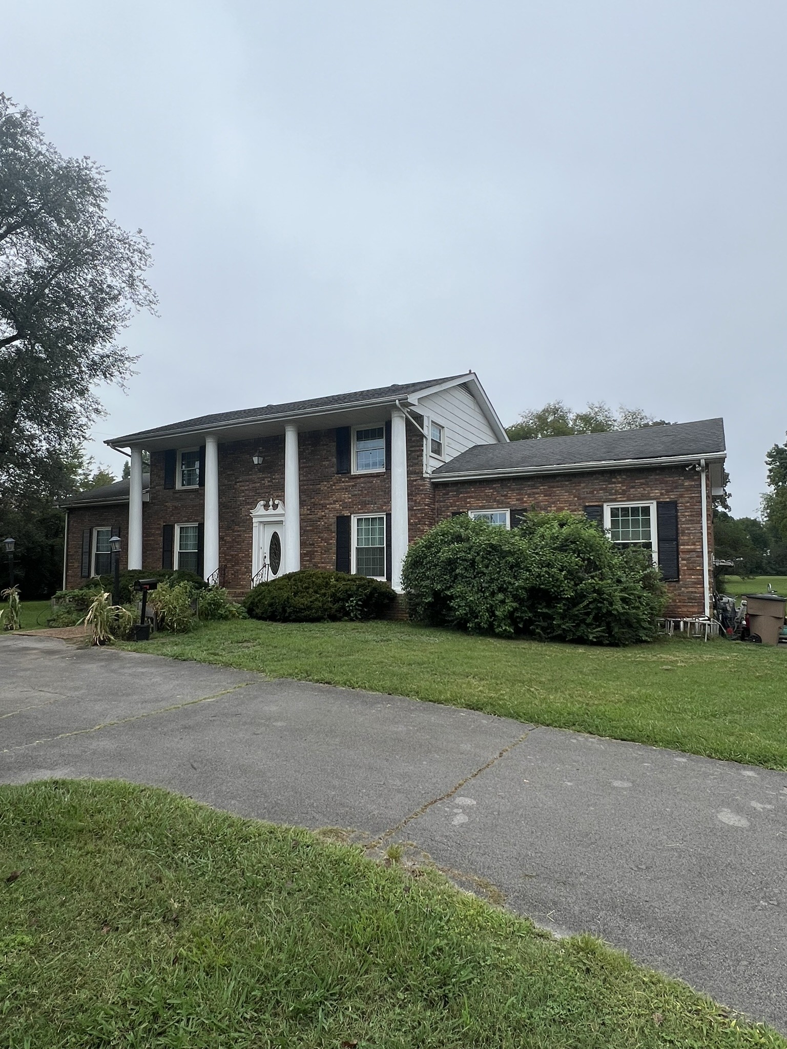 a front view of a house with a yard and trees