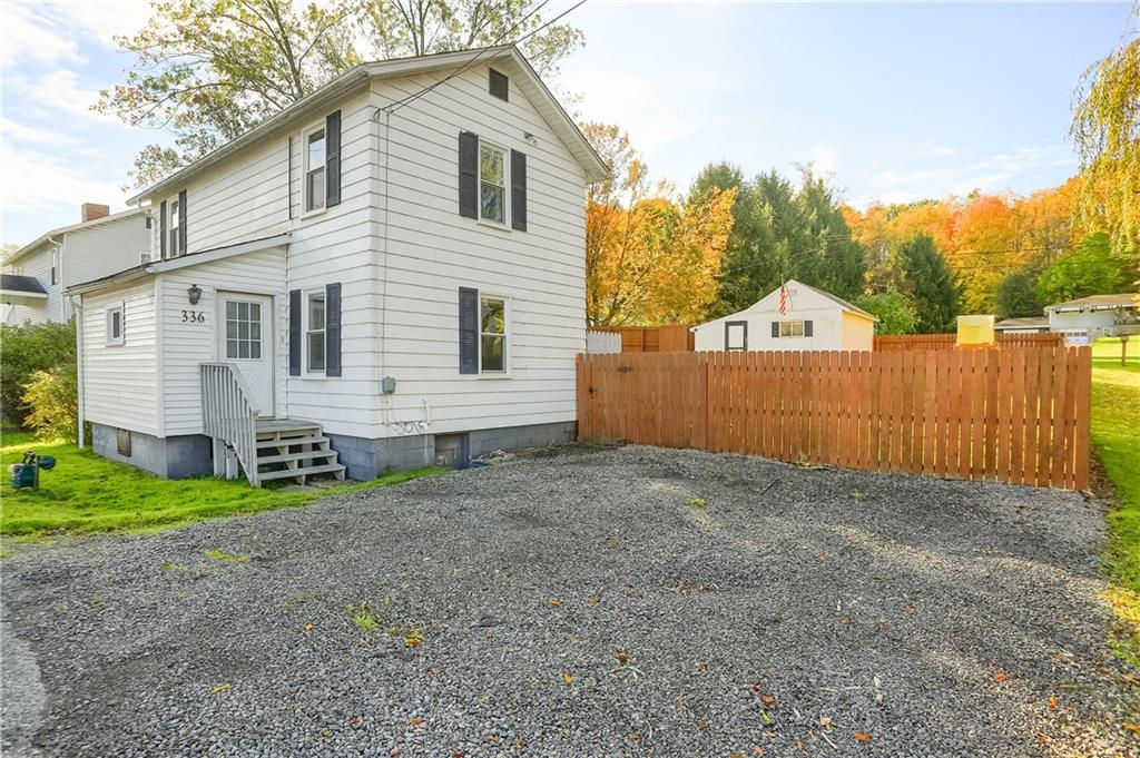 a view of a house with a backyard and a tree