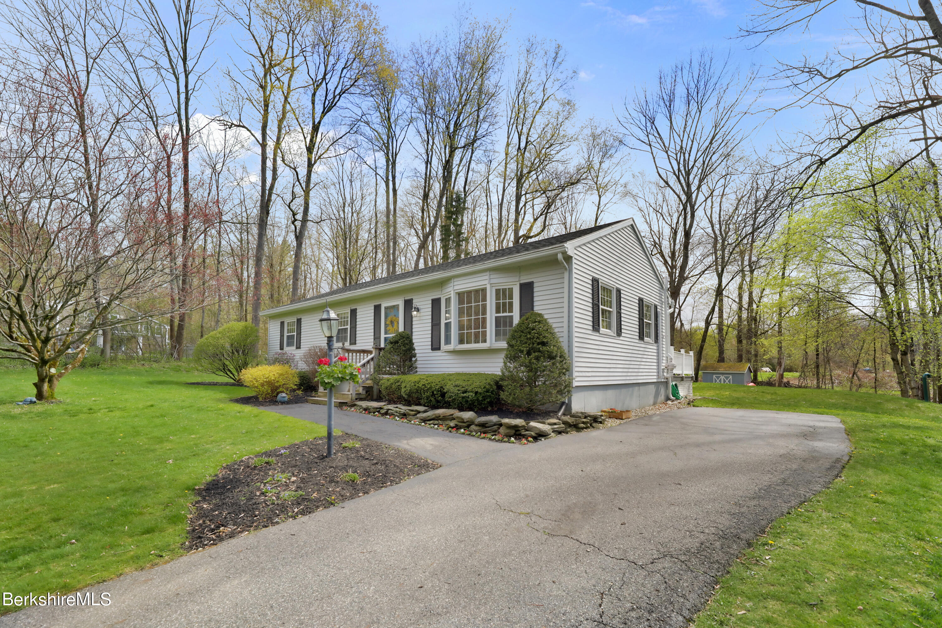 a view of a house with backyard and trees