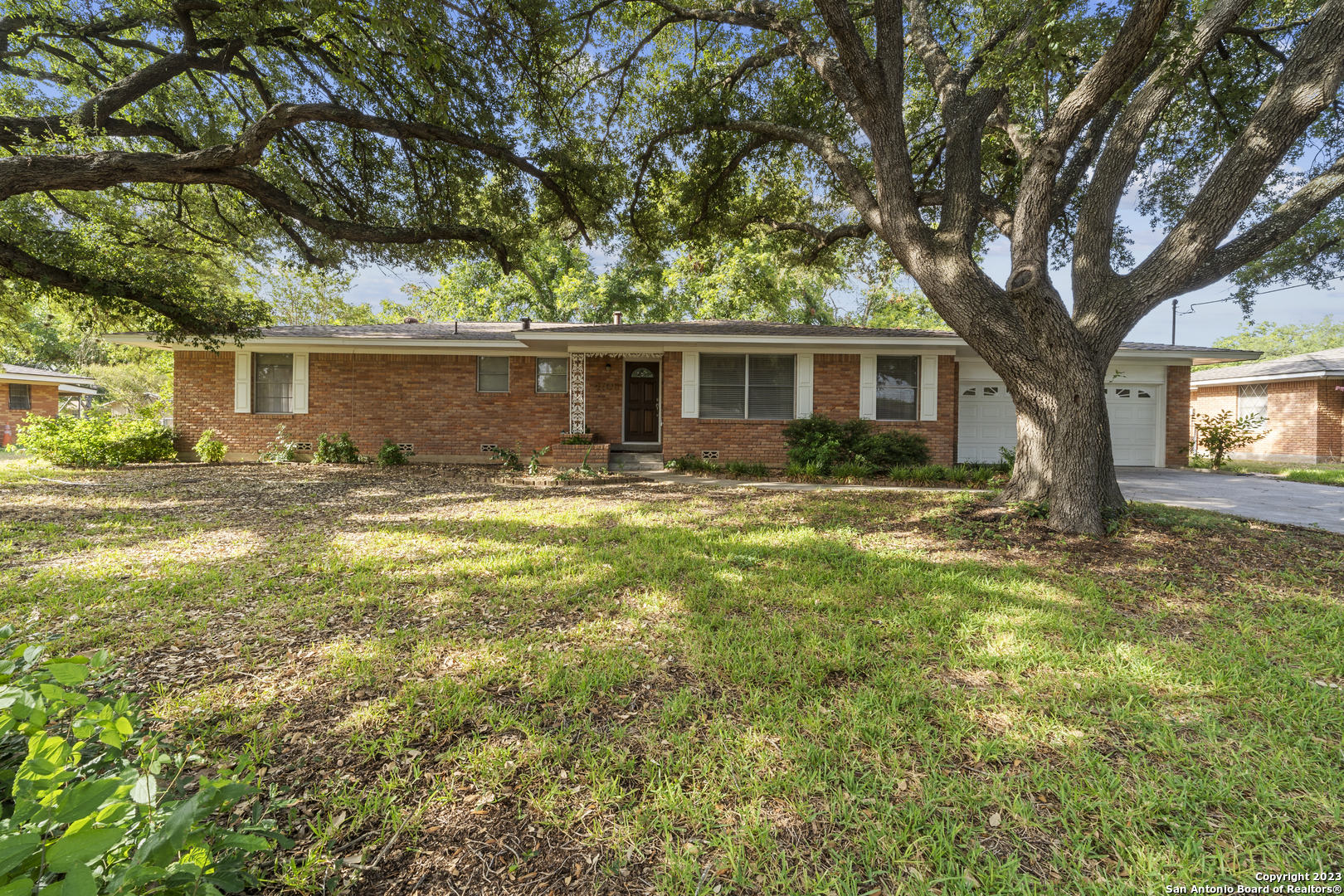 a front view of house with yard and trees around