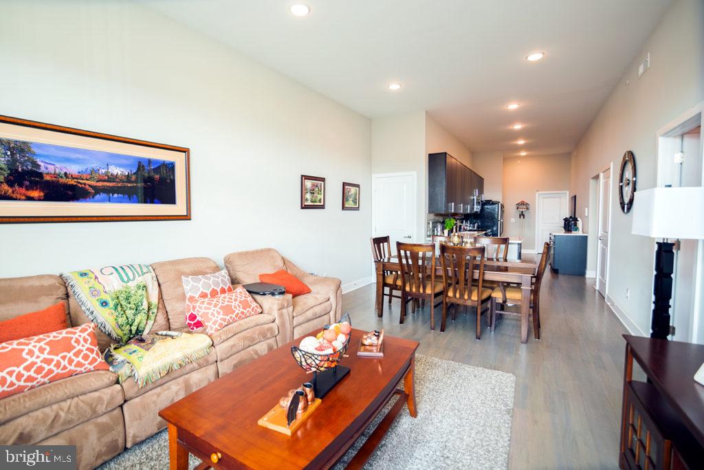 a living room with furniture and a dining table with kitchen view