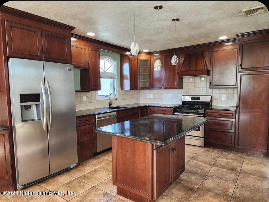 a kitchen with stainless steel appliances granite countertop a refrigerator a sink and a stove