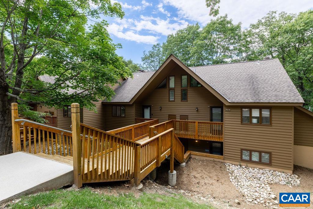 a view of backyard with deck and outdoor seating