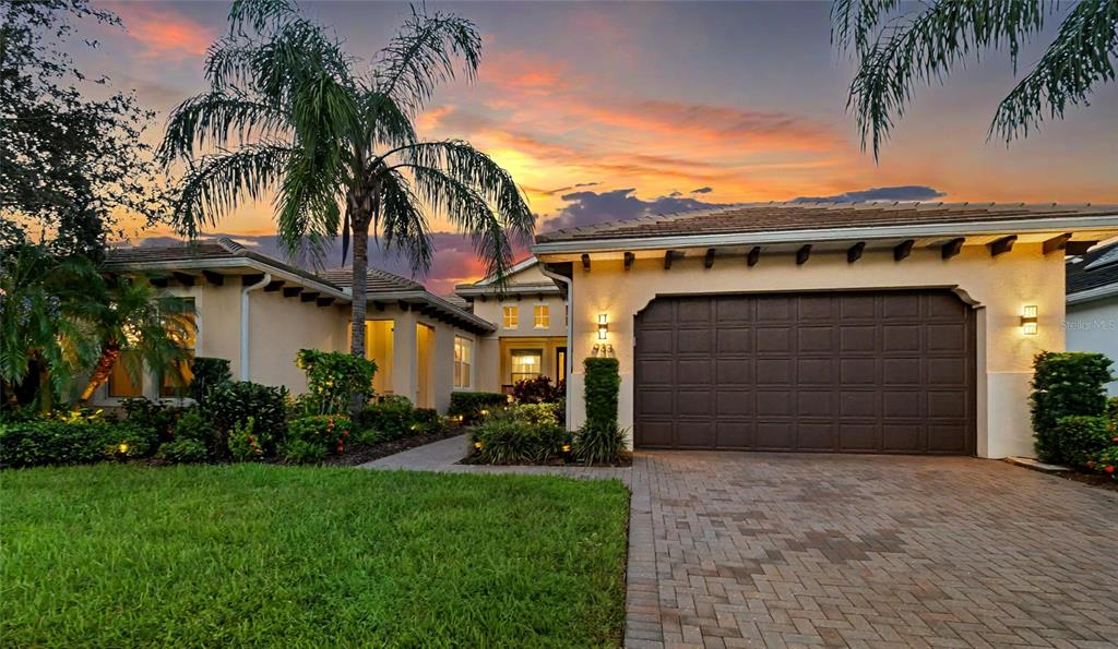 front view of a house with a yard and palm trees