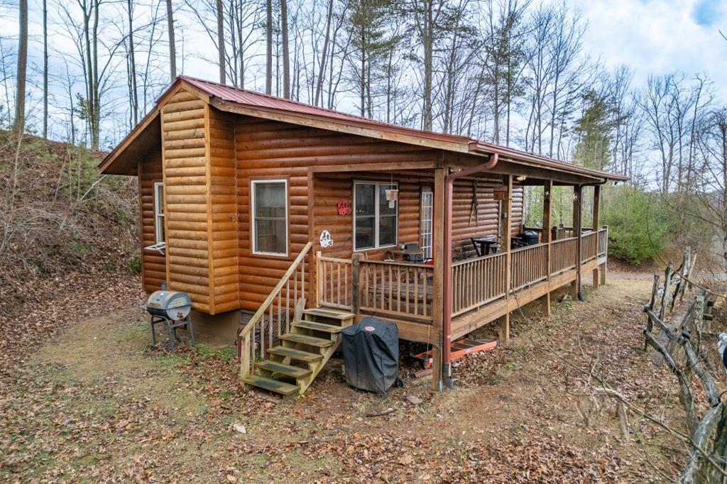 a view of a house with a yard and wooden deck