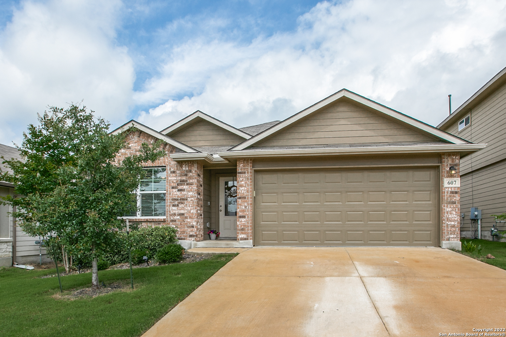 a front view of a house with a garden and garage