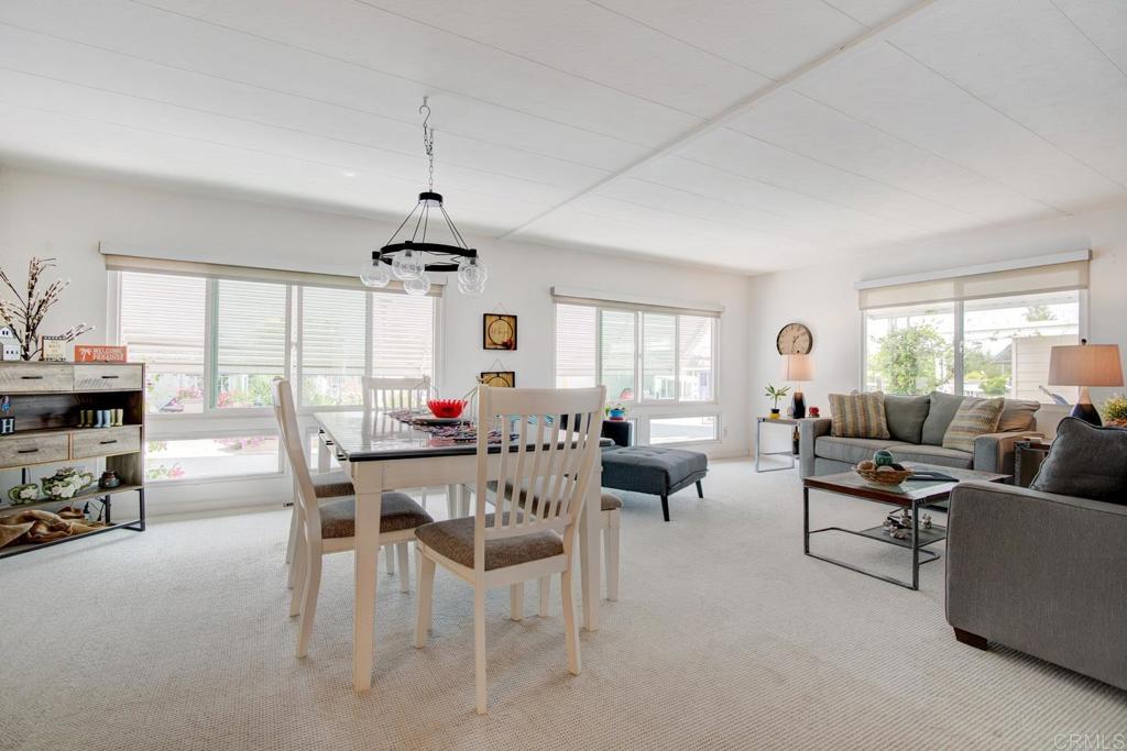 a living room with furniture a dining table and a large window