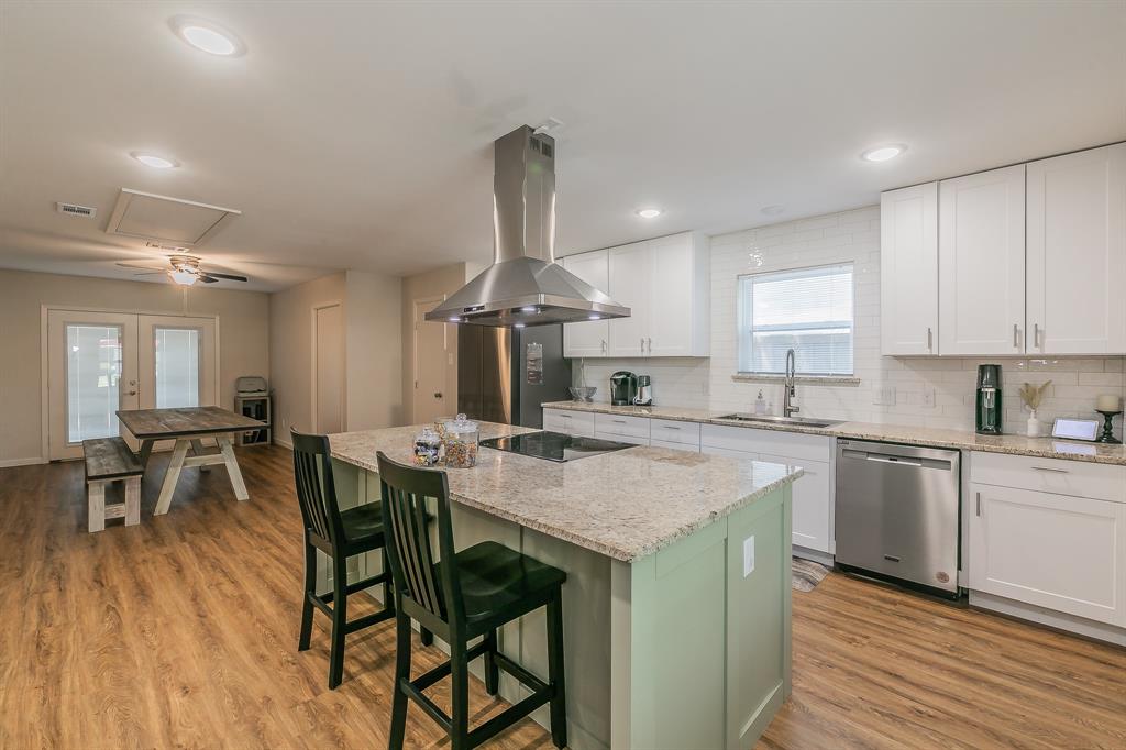 a kitchen with stainless steel appliances granite countertop table chairs sink and cabinets