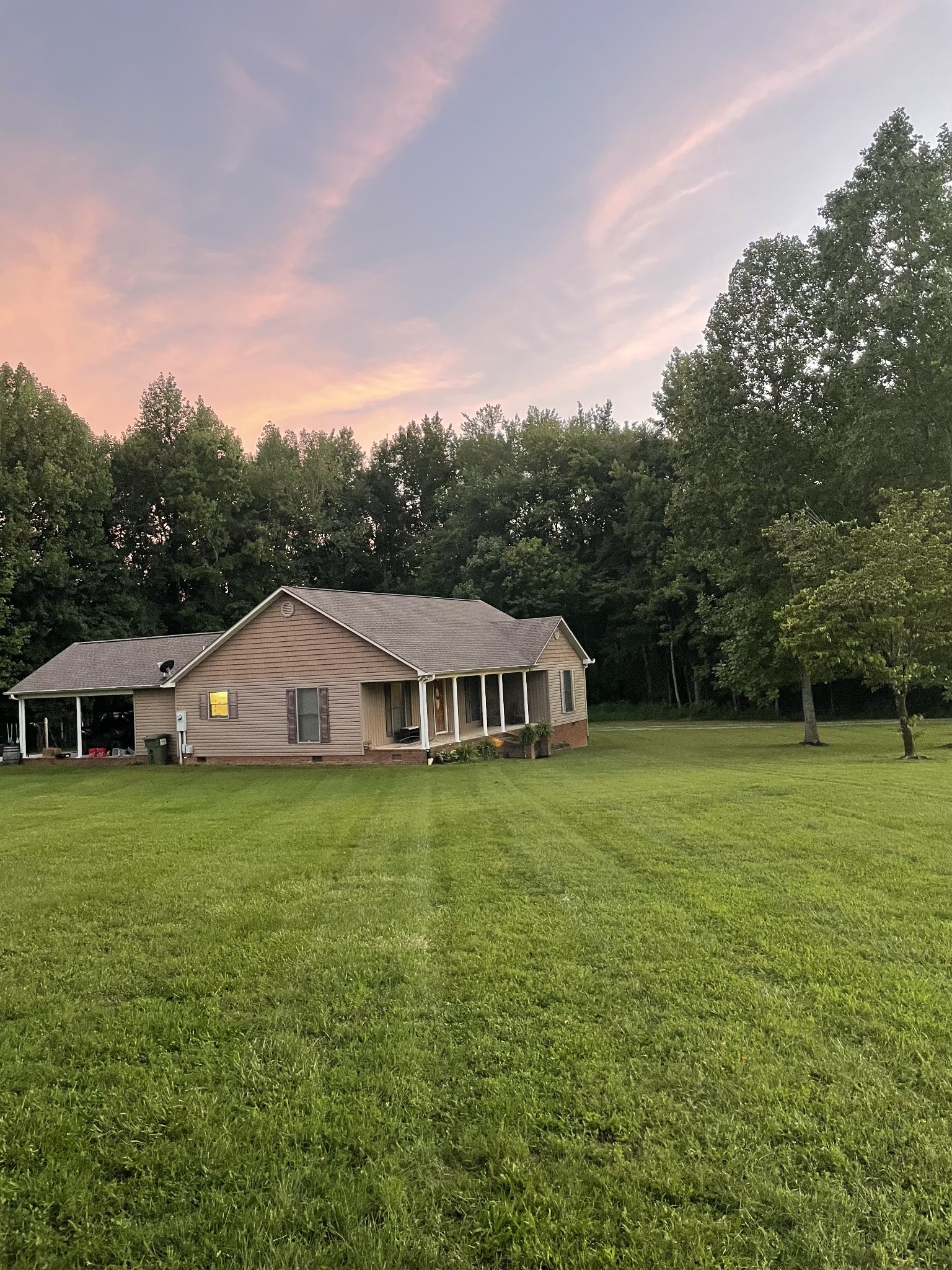 a view of a big yard with a house in the background