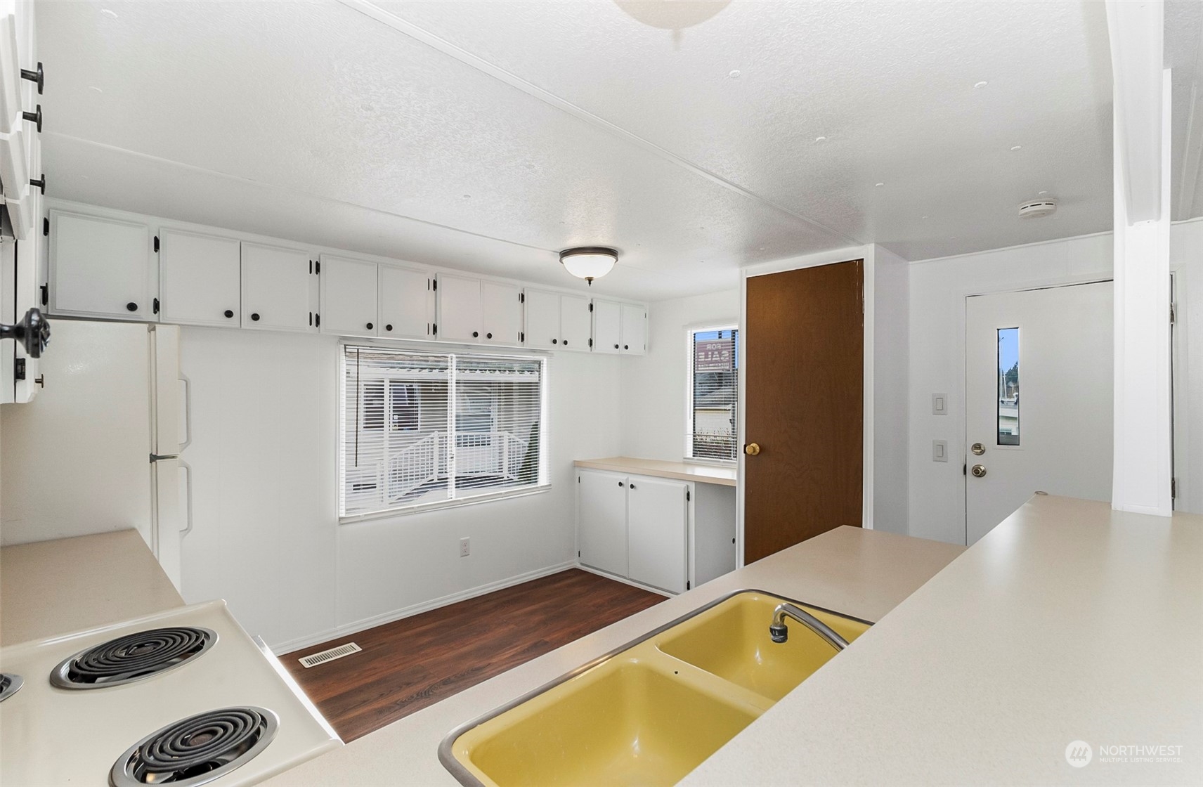 a room with a bed and a view of kitchen