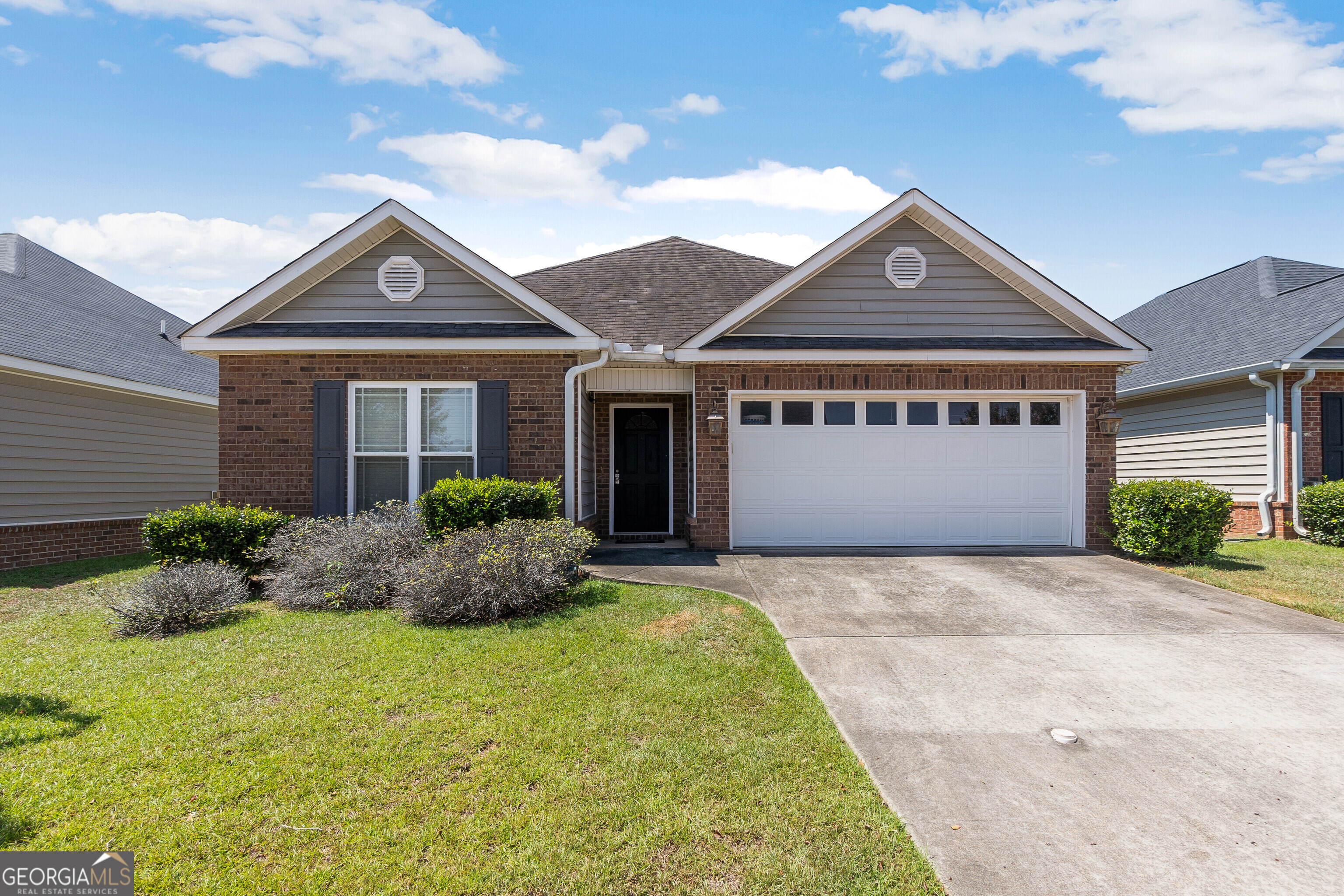 a front view of a house with a yard and garage