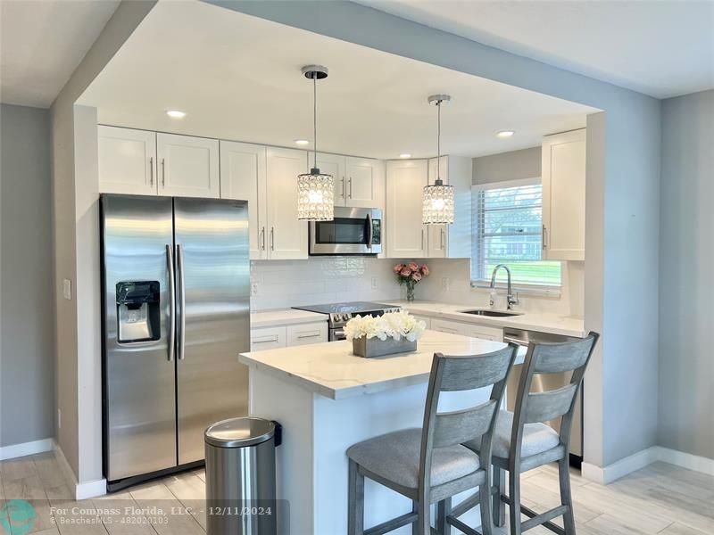 a kitchen with refrigerator a sink and white cabinets