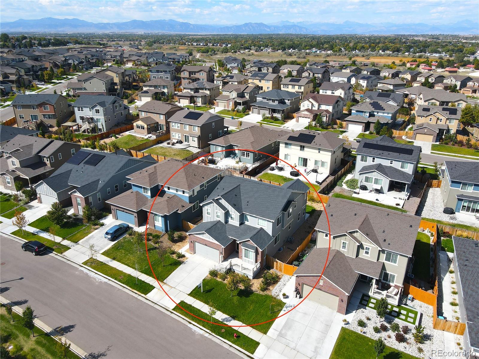 an aerial view of a city with lots of residential buildings and mountain view in back