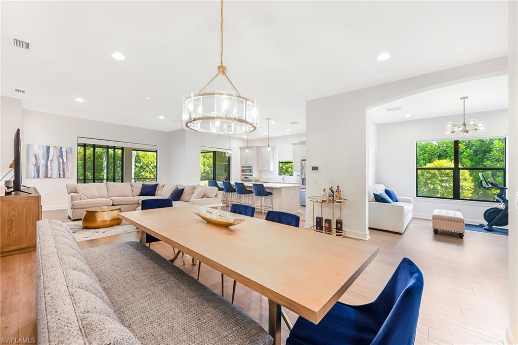 a view of a dining room and livingroom with furniture wooden floor a chandelier