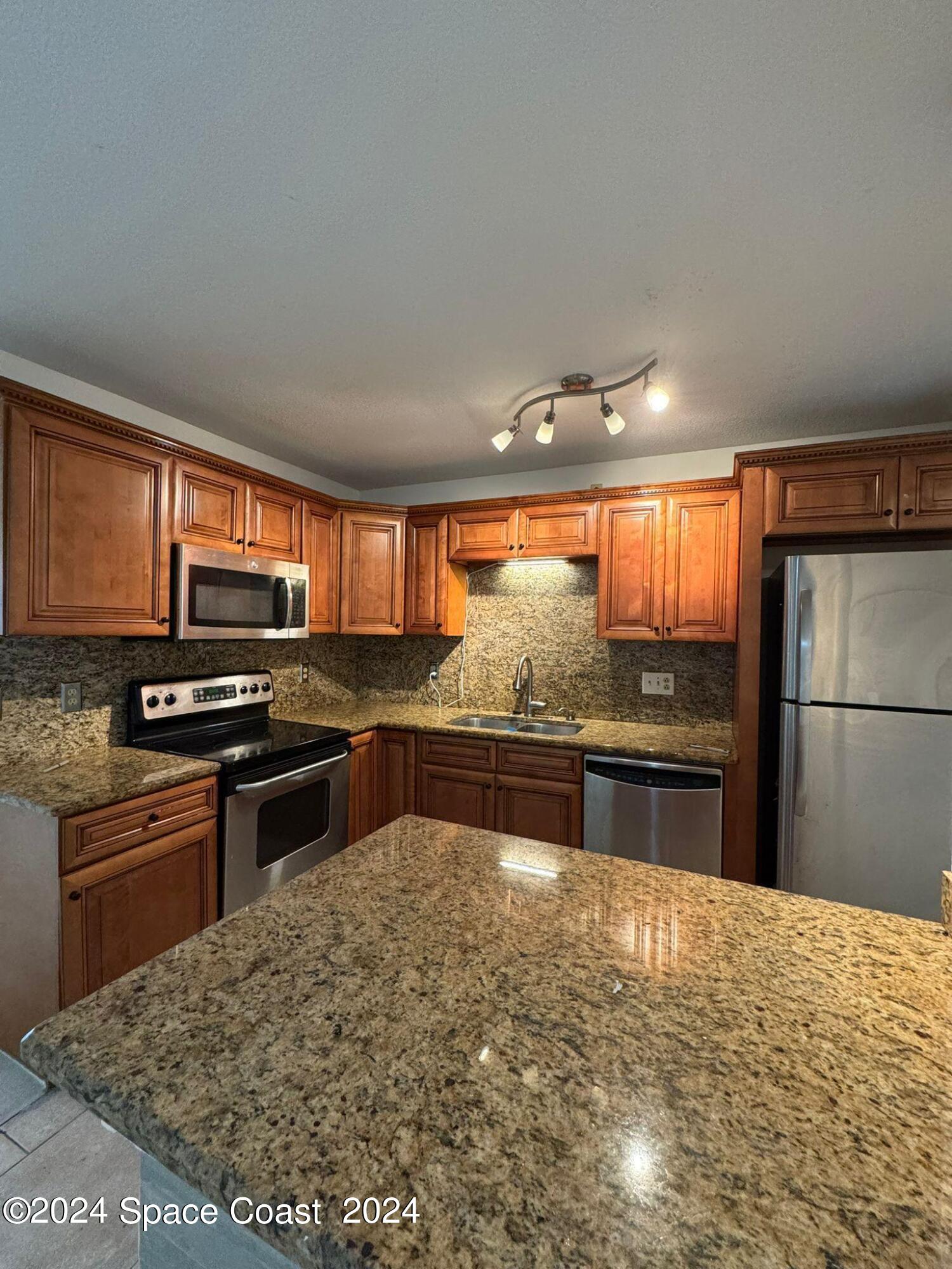 a kitchen with stainless steel appliances granite countertop a stove a sink and a microwave