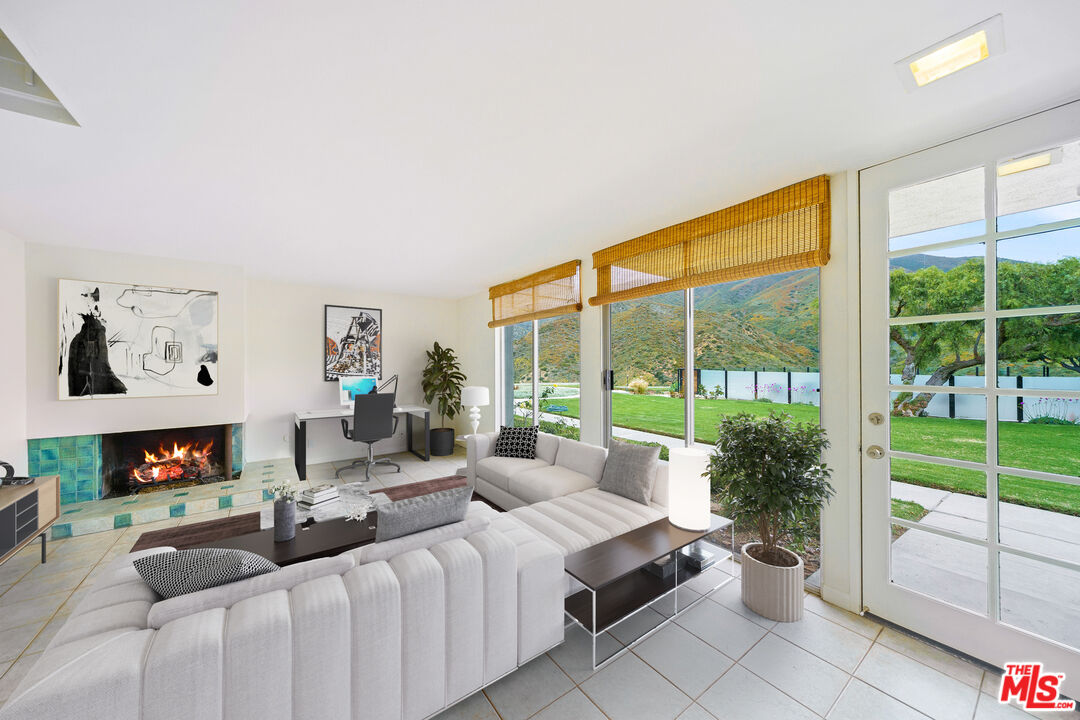 a living room with furniture a flat screen tv and a floor to ceiling window