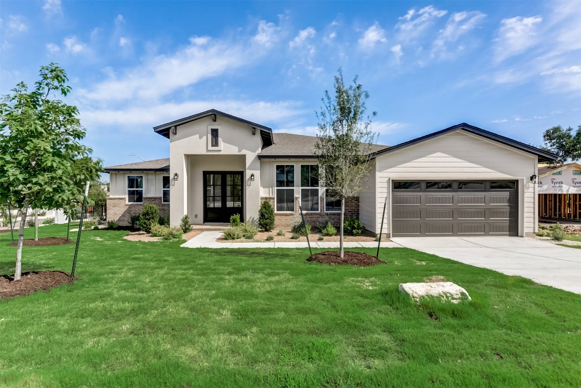 a front view of a house with a yard and garage