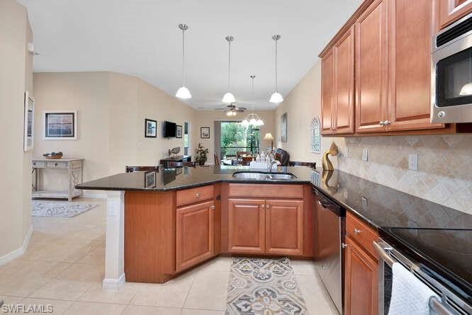 a kitchen with stainless steel appliances granite countertop wooden cabinets a sink and a stove