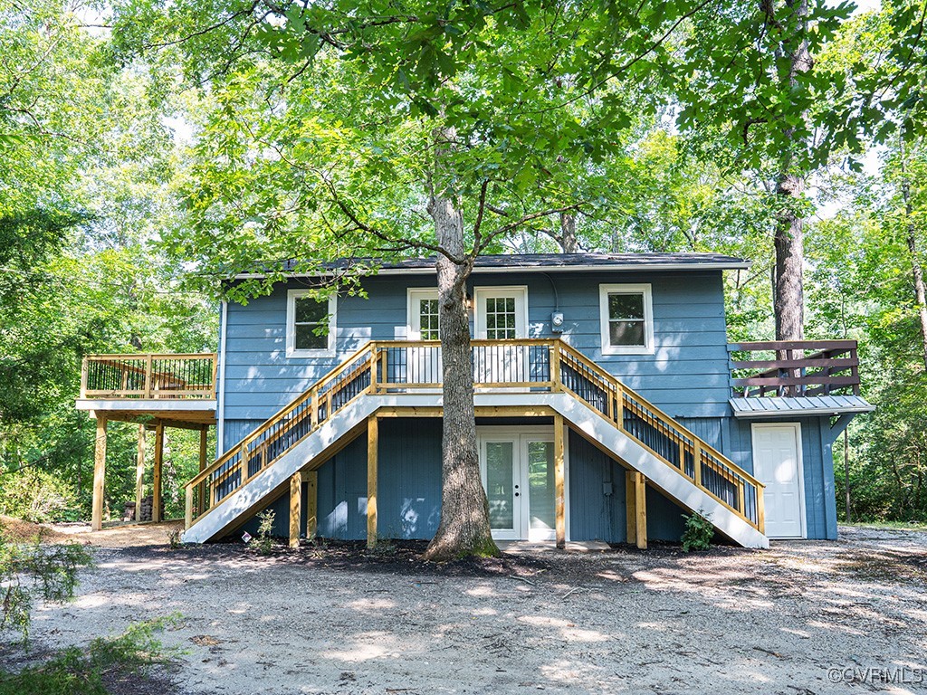 a house that has a wooden fence and a large tree