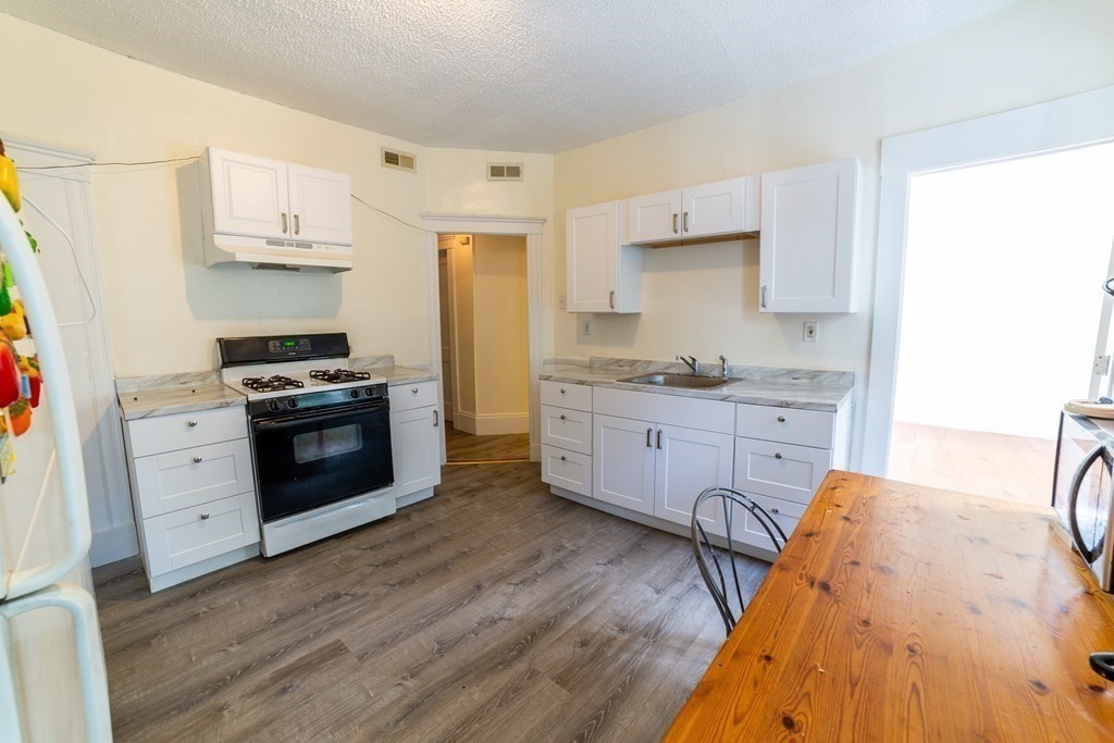 a kitchen with stainless steel appliances kitchen island granite countertop a stove a sink and a refrigerator