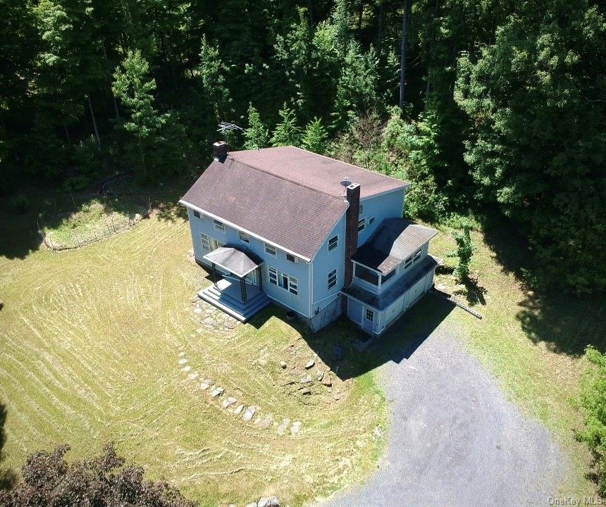 a aerial view of a house with swimming pool and large trees