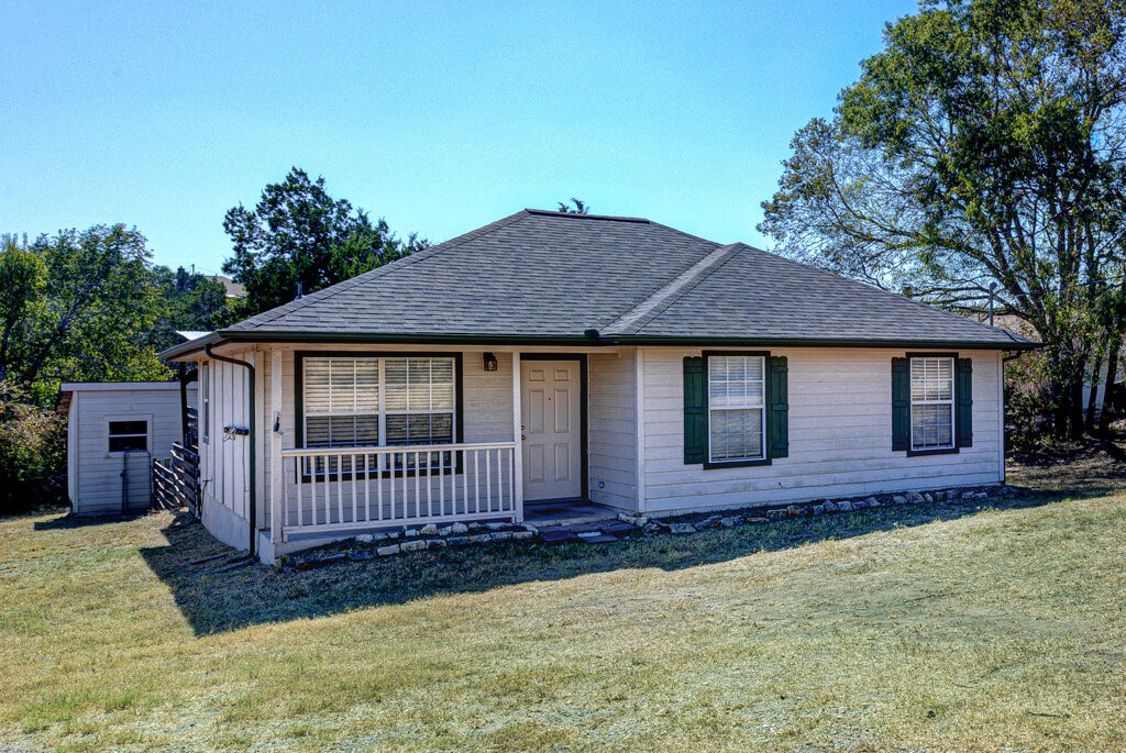 a view of a house with wooden fence and a yard