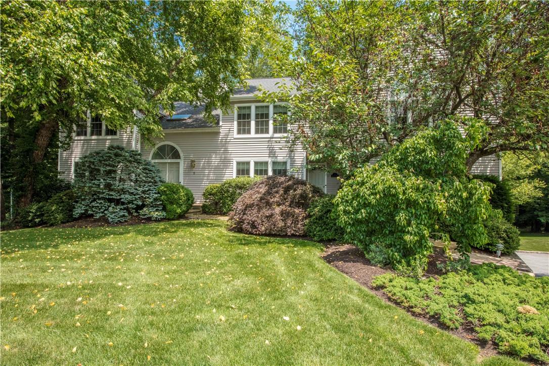 a view of a house with a big yard and large trees