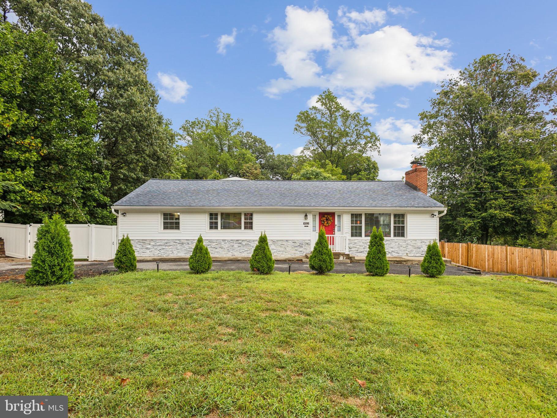 a view of a yard in front of a house with large tree