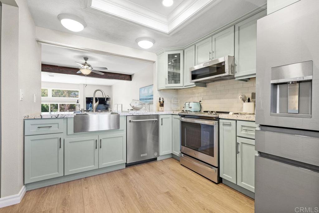 a kitchen with stainless steel appliances a sink cabinets and a window